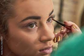 hand applying makeup female model face