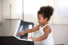 mix race kid practice to play piano in
