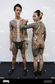 NOTE NUDITY Graffiti artist Debe (left), aged 28, and tattoo artist Hori  Mayi, 29, both from Taiwan, attending the London International Tattoo  Convention at Tobacco Dock in London Stock Photo - Alamy