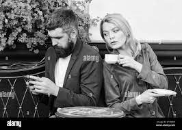 Married lovely couple relaxing together. Couple cafe terrace drink coffee.  Couple in love sit cafe terrace enjoy coffee. Man secret messaging cheating  on wife. Cheat and betrayal. Family weekend Stock Photo -