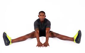 muscular man stretching legs on sitting
