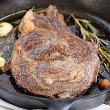 pan seared ribeye steak cooking with