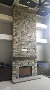 Floor To Ceiling Stone Veneer Fireplace