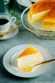 a sliced anese cheesecake on a plate and a cup of coffee