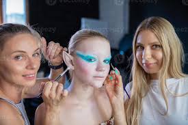 two women applies creative makeup to