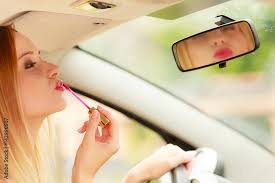 woman applying makeup while driving her