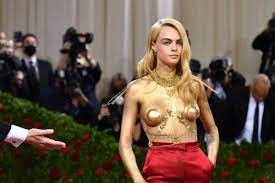 Cara Delevingne paints breasts gold for Met Gala