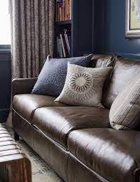 brown leather sofa with throw pillows