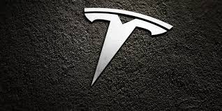 It's a white logo set against a black background. 5 Business Principles That Transformed Tesla From Running Out Of Cash To The Most Exciting Car Company In The World
