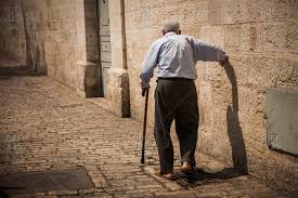 An old man walks down the street in the Arab Quarter of Jerusalem stock  photo - OFFSET