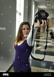 female woman photographer taking her own image picture with camera in air  pointing downward 