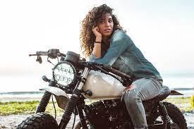 female biker driving a cafe racer motorbike