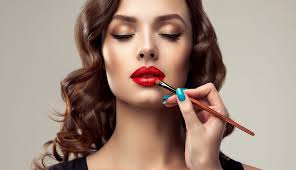 makeup artist applies red lipstick