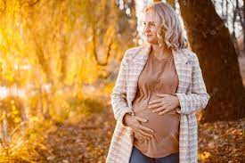 Free Photo | Portrait of middleaged pregnant woman outdoors at park middle  age pregnant woman expecting baby at aged pregnancy blonde woman wearing  brown sweater and beige coat