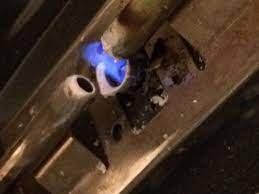 pilot light on gas stove touches one of