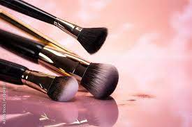 makeup brushes on a pink background