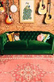 green velvet tufted sofa and pink rug