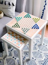 Create this hanging chess board game using pieces of wood, crown molding, stain, polyurethane, paint, painter's tape, wood glue, cylindrical dowels, rubber bands, square dowels, electric drill, drill bits, table saw, circular saw, and clamps. Free Game Table Plans