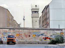 Paint brushes in paper cups on white wall. Berlin Wall Art The Wall Before The Fall