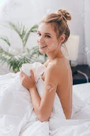 Attractive Smiling Nude Woman With Cup Of Coffee Sitting In Bed In Morning  Stock Photo, Picture and Royalty Free Image. Image 139336399.