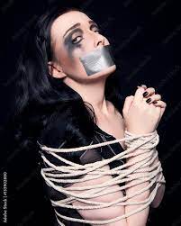 Foto Stock Young woman gagged and tied up with rope | Adobe Stock