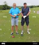 Two golfers standing on a tee box with drivers in hand,on a golf ...