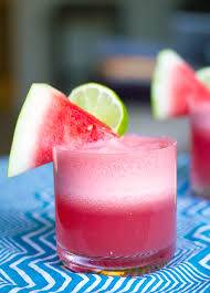 head on view of a watermelon coconut l with watermelon wedge and lime round garnish