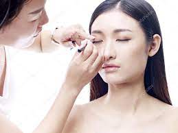 makeup artist working on a female asian