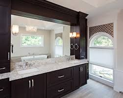 A wood floor and vanity give this city bathroom a warm and serene feeling. Cherry Bathroom Vanity With A Dark Finish Crystal Cabinets