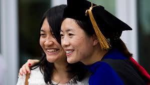 Lingling Yuan (left) poses with Yonghua Teng after the All-University Commencement at Pinnacle Bank Arena on Aug. 16. - MS14081614