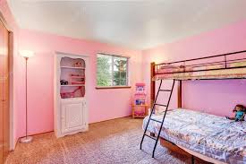 pink kids bedroom with white furniture