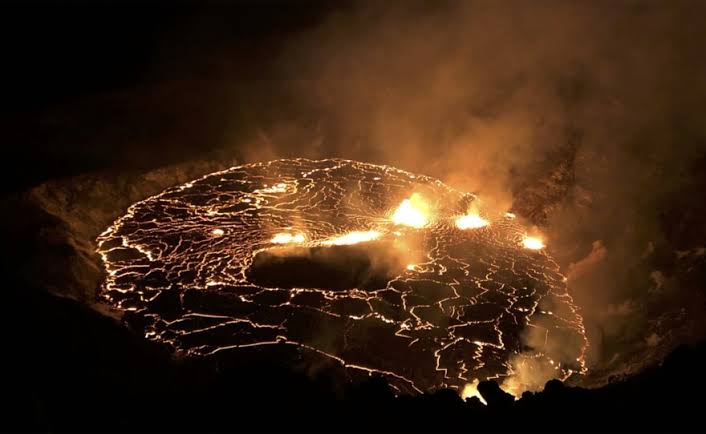 Active lava fountaining illuminating the floor of the summit crater, AI generated