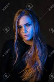 Blonde With Long Hair In Black Poses In Black Studio With Blue