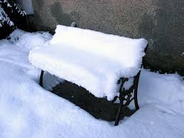 photo of snow covered garden bench