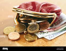 Cierre de billetes y monedero derramando monedas Fotografía de stock - Alamy