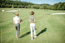friends walking with golf putters