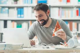 Smiling Man Having A Lunch Break At Office He Is Eating A Slice