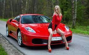 model posing with a red ferrari blonde