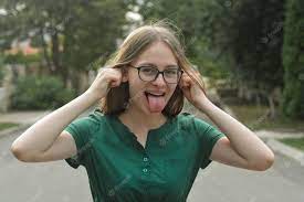 Premium Photo | Close-up portrait of funny teen girl smiling, having fun in  green dress and open mouth with stuck out tounge.