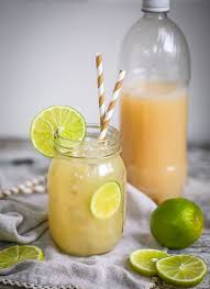 homemade ginger beer served over ice in a mason jar with lime slices and garnished with