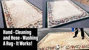 hand cleaning and hose washing a rug