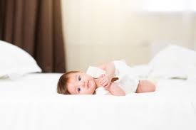 cute 3 month baby girl in white bedding