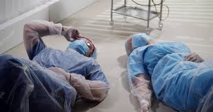 Médicos cansados em uniforme estéril deitado no chão no quarto do hospital  | Foto Premium
