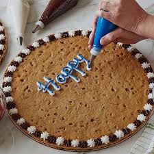 A football festive chocolate chip cookie cake that will surely wow your game day crowd! Cookie Cakes Great American Cookies