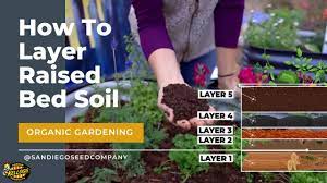 layering soil in a raised garden bed
