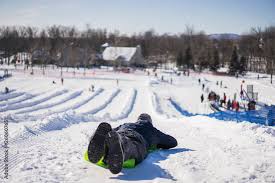 man using crazy carpet type sled to