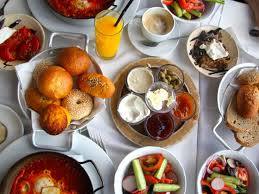 A breakfast of salt cod cake, fried eggs and avocado mojo (right), cardamom granola, yoghurt and fruit salad (centre) or huevos rotos. Serious Entertaining Israeli Breakfast