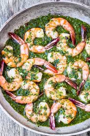 chimichurri shrimp in bright green sauce in a pan