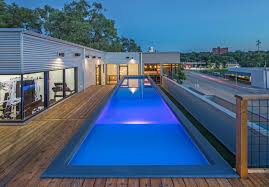 A tiny and sleek brightly lit pool tucked between a deck and the wall of the house. Modpools Shipping Container Pools Home