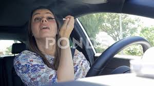 woman driving while putting makeup not